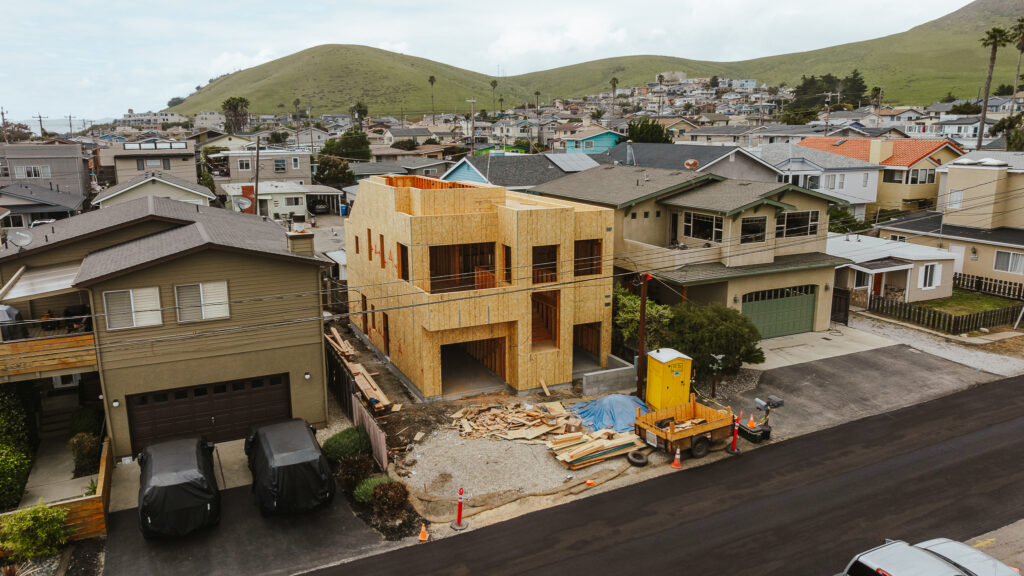 Multi-story custom home in Morro Bay, California, featuring a rooftop deck with ocean views and structural engineering by Studio Prime Engineering.